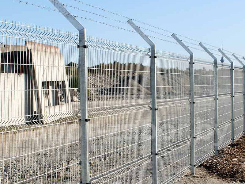 Фото еврозабора для ограждения строительной площадки с защитным барьером из колючей проволоки