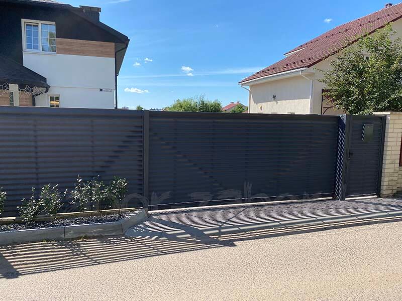 Фото откатных ворот-жалюзи с калиткой графитового цвета